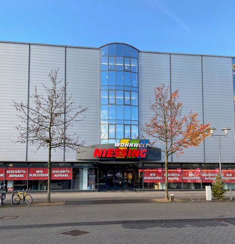 Umnutzung eines Möbelhauses in ein Wohn- und Geschäftshaus